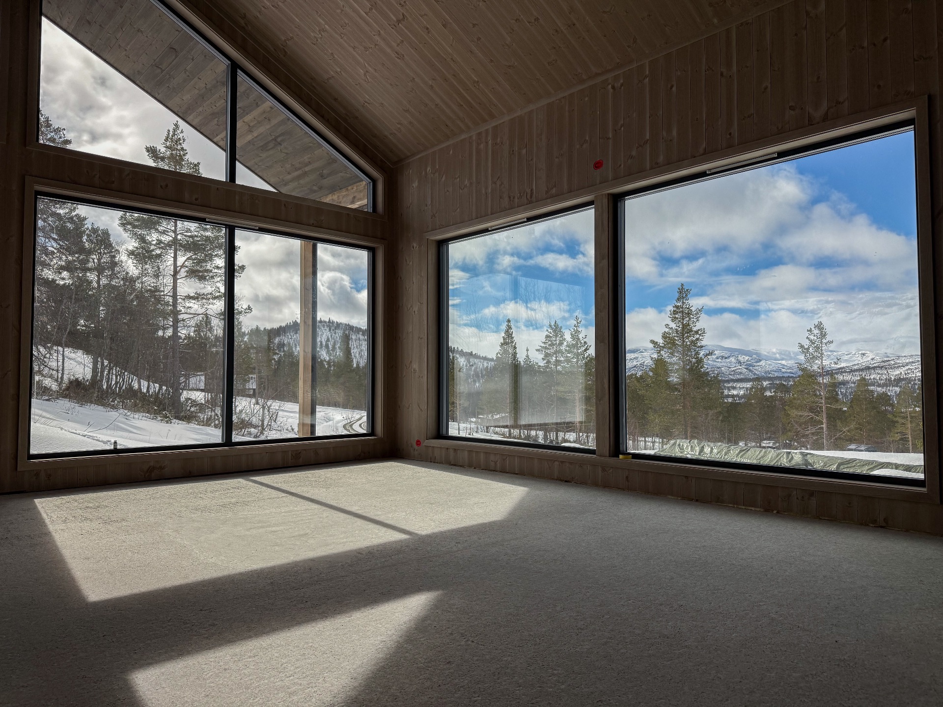 Stue og kjøkken med store vinduer mot nydelig utsikt!