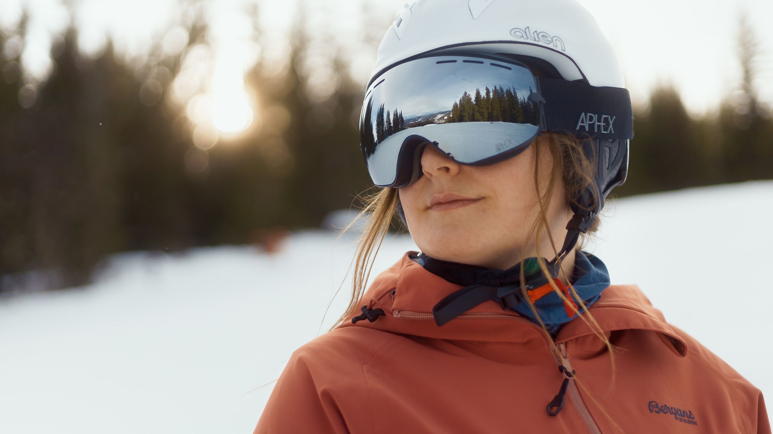 Ung skiløper med hvit hjelm og skibriller i bakken